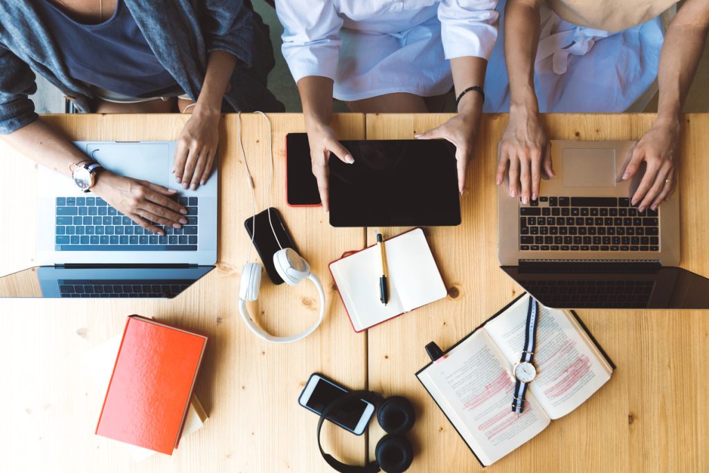 Women sat at computers and tablets brainstorming ideas 