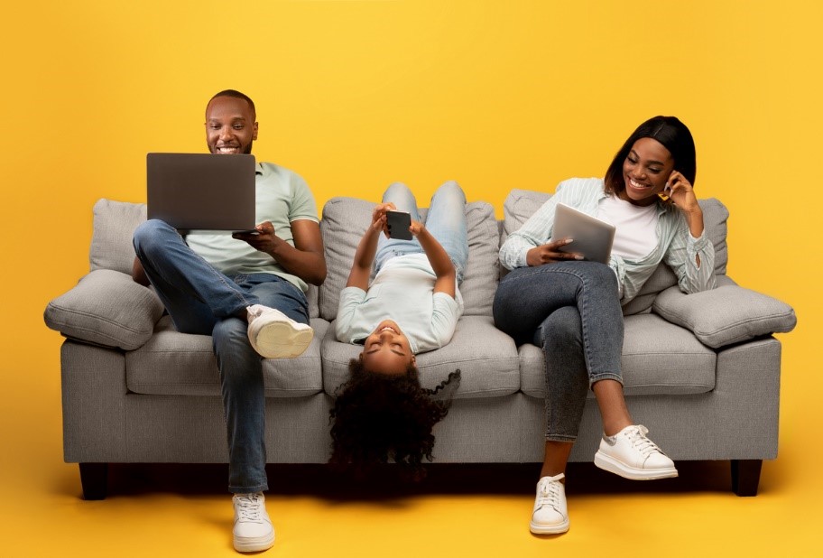 Family on sofa on different devices with yellow background