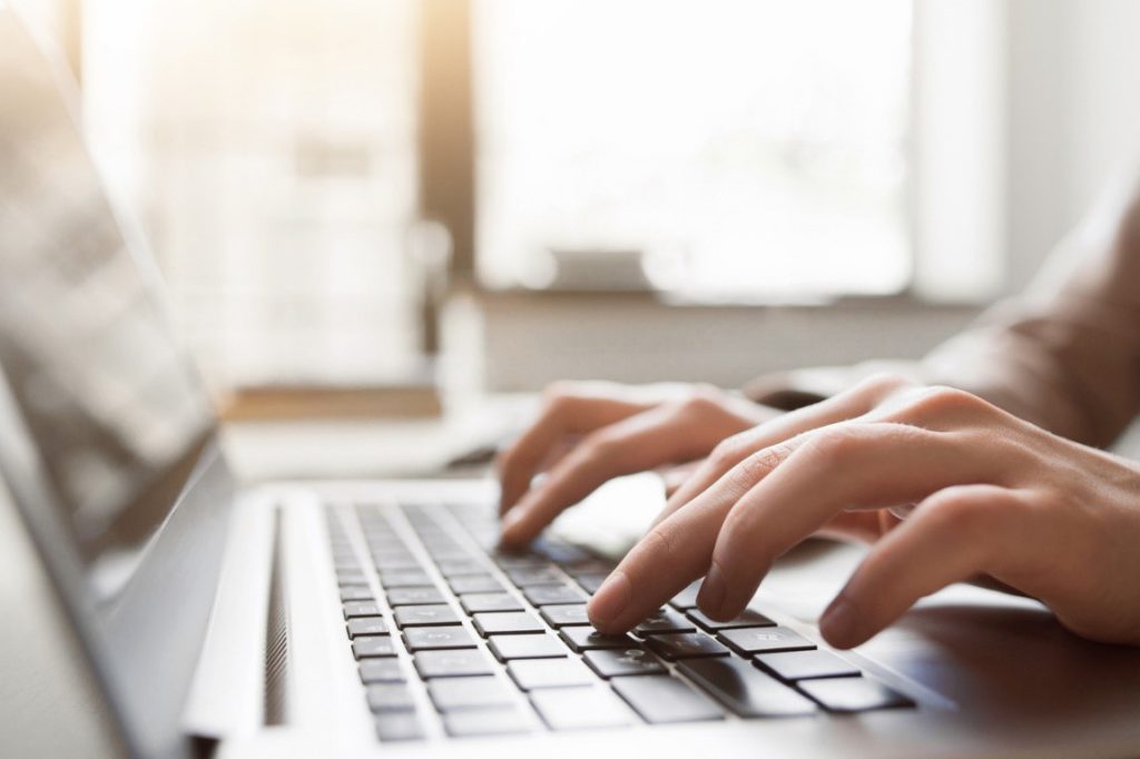 Fingers typing on a laptop keyboard