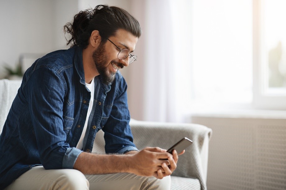 Man scrolling on phone smiling