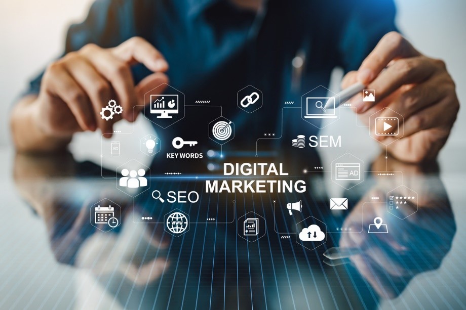 the words digital marketing surrounded by digital marketing symbols and phrases with hands in the background