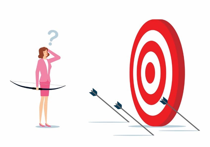 A person holding a bow and arrow in front of a target 
