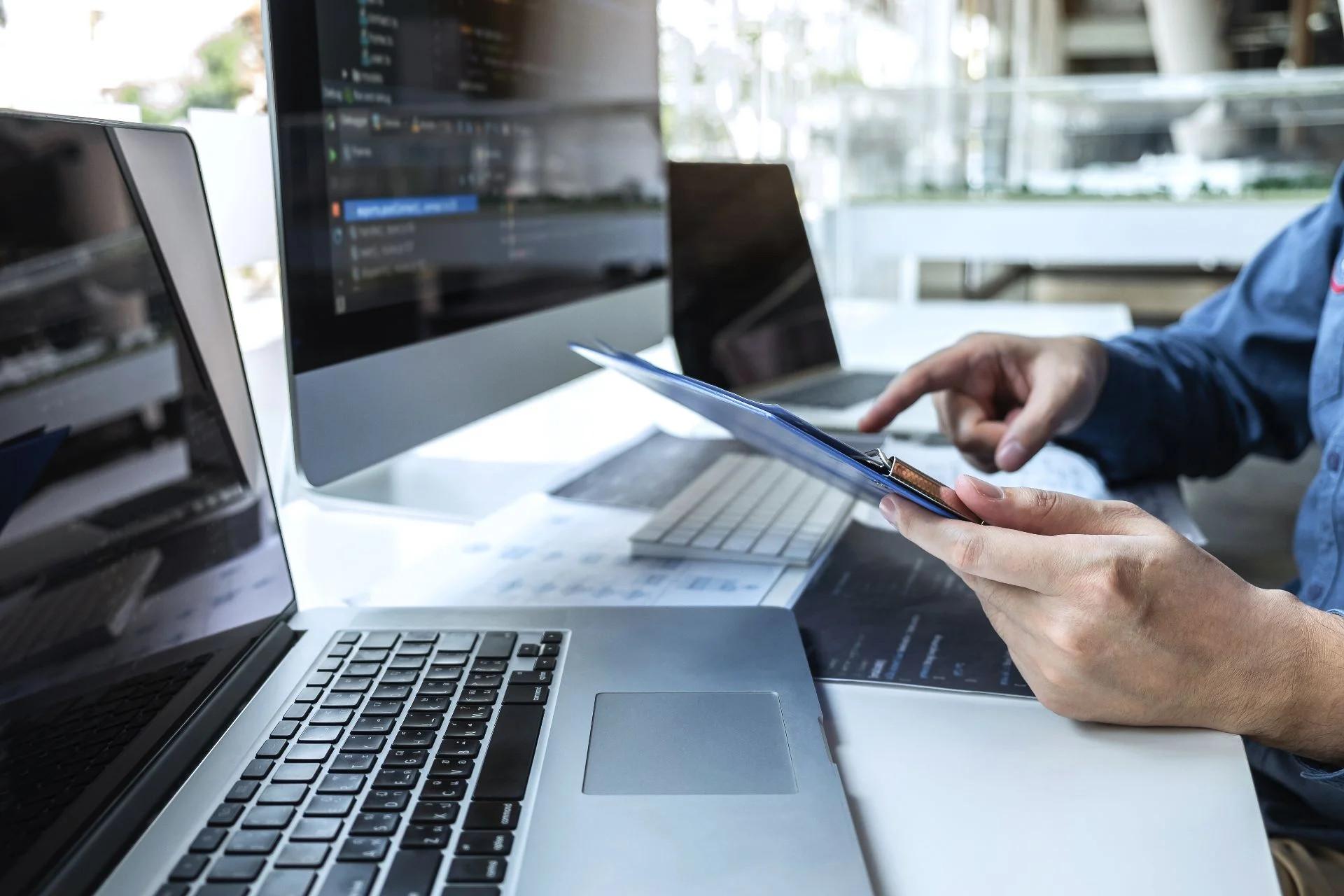 man working in an office with multiple laptops